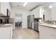 Well-equipped kitchen with white cabinets, granite countertops, and modern stainless appliances at 220 Cameron Ways, Covington, GA 30016