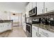 Modern kitchen with white cabinetry, granite countertops, and stainless appliances at 220 Cameron Ways, Covington, GA 30016