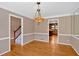 Charming dining room showcasing hardwood floors, an ornate chandelier, and views to staircase and kitchen at 4508 Club House Dr, Marietta, GA 30066