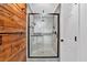 Modern glass-enclosed shower with river rock base and wood accent wall at 4508 Club House Dr, Marietta, GA 30066