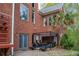 Brick home with a patio including a dining table, chairs, and surrounding trees at 4799 Winterview Ln, Douglasville, GA 30135