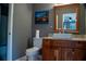 Bathroom featuring granite vanity with ceramic sink, new toilet, and vanity mirror at 4799 Winterview Ln, Douglasville, GA 30135