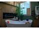 Relaxing bathroom with a freestanding tub, electric fireplace, and decorative plants, creating a serene ambiance at 4799 Winterview Ln, Douglasville, GA 30135
