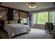 A cozy bedroom with large windows bringing the beauty of nature inside at 4799 Winterview Ln, Douglasville, GA 30135