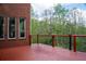 Red wooden deck with views of the surrounding trees and nature at 4799 Winterview Ln, Douglasville, GA 30135