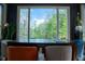 Dining area with large window offering wooded view, dark table, and colorful chairs, creating a cozy and inviting space at 4799 Winterview Ln, Douglasville, GA 30135
