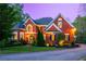 Charming brick home with manicured lawn, mature trees, and an inviting circular driveway at twilight at 4799 Winterview Ln, Douglasville, GA 30135