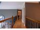 Well-lit hallway with hardwood floors, decorative railing, and neutral tones, connecting various living spaces seamlessly at 4799 Winterview Ln, Douglasville, GA 30135
