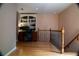 Hallway with hardwood floors, open landing, wooden railing, built-in shelving and natural light at 4799 Winterview Ln, Douglasville, GA 30135
