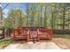 Large backyard with deck surrounded by mature trees and privacy fence at 7228 Silverleaf Cir, Fairburn, GA 30213