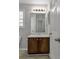Bathroom with brown vanity, sink and white cabinets and white tile floors at 7228 Silverleaf Cir, Fairburn, GA 30213