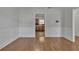 Bright dining room featuring hardwood floors and white wainscoting, flowing to kitchen at 7228 Silverleaf Cir, Fairburn, GA 30213