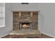 Close-up on stone fireplace with wooden mantel and stone hearth, perfect for cozy evenings at 7228 Silverleaf Cir, Fairburn, GA 30213