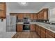 Modern kitchen featuring stainless appliances, dark backsplash, granite counters, and wood cabinets at 7228 Silverleaf Cir, Fairburn, GA 30213