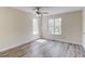 Spacious bedroom with wood-look flooring, large windows, and a ceiling fan for comfort at 11205 Abbotts Station Dr, Duluth, GA 30097