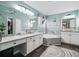 Bright bathroom featuring dual sinks, soaking tub, vanity area, and decorative rug at 1490 Rivershyre Pkwy, Lawrenceville, GA 30043