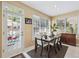 Dining area with a dark wood table, white chairs, and bright natural light with a view of the pool at 1490 Rivershyre Pkwy, Lawrenceville, GA 30043