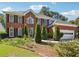Charming two-story brick home featuring a well-manicured lawn and an attached two-car garage at 1490 Rivershyre Pkwy, Lawrenceville, GA 30043