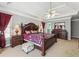 Bedroom with tray ceiling, a ceiling fan, dark wood furniture, and ample closet space at 1490 Rivershyre Pkwy, Lawrenceville, GA 30043