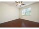 Cozy bedroom featuring dark wood floors, a ceiling fan, and a bright window overlooking outdoor greenery at 548 W Oaks Dr, Woodstock, GA 30188