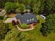 Aerial view of a beautiful brick home on lush landscaped grounds with mature trees and an outbuilding at 200 Sugar Mill Ln, Canton, GA 30115