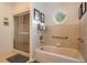 Bright bathroom features a shower, bathtub, handrails, and an octagon window that provides natural light at 200 Sugar Mill Ln, Canton, GA 30115