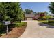 Exterior of house featuring wide driveway and lush greenery, including plants and trees, plus a mailbox in the front yard at 200 Sugar Mill Ln, Canton, GA 30115