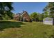 Sprawling exterior view of house and shed showcasing manicured lawn, colorful shrubs, and lush landscaping around the perimeter at 200 Sugar Mill Ln, Canton, GA 30115