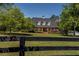 Landscaped yard in front of this home featuring green grass, and black wood fence at 200 Sugar Mill Ln, Canton, GA 30115