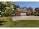 Exterior of a house featuring an attached garage with a wide driveway and beautifully landscaped lawn on a sunny day at 200 Sugar Mill Ln, Canton, GA 30115