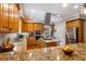 A kitchen with wooden cabinets, granite countertops, stainless steel appliances, and a central island cooktop at 200 Sugar Mill Ln, Canton, GA 30115