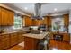 A kitchen with wooden cabinets, granite countertops, stainless steel appliances, and a central island with a cooktop at 200 Sugar Mill Ln, Canton, GA 30115
