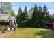 Backyard with grass, stairs leading to a deck, and lush greenery at 1105 Westbrooke Ne Way, Brookhaven, GA 30319