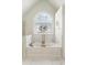 A beautifully tiled soaking tub is bathed in light from a stained glass window at 1105 Westbrooke Ne Way, Brookhaven, GA 30319