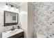 Charming powder room with floral wallpaper, stylish lighting, and framed mirror at 1105 Westbrooke Ne Way, Brookhaven, GA 30319