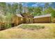 Rear exterior view of a brick home with an elevated deck and a spacious yard at 1660 Weems Rd, Locust Grove, GA 30248