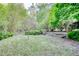 Lush backyard with established trees and groundcover, offers a serene, private outdoor space at 1660 Weems Rd, Locust Grove, GA 30248