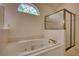 Bright bathroom featuring a large tub with jets and a separate glass-enclosed shower at 1660 Weems Rd, Locust Grove, GA 30248