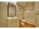 Bathroom with toilet, tub, and sink with large mirror above and hardwood floors at 1660 Weems Rd, Locust Grove, GA 30248
