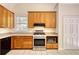 Traditional kitchen features wood cabinets, stainless steel range, and tile flooring at 1660 Weems Rd, Locust Grove, GA 30248