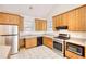 Kitchen with stainless steel appliances, oak cabinets, and tile floors at 1660 Weems Rd, Locust Grove, GA 30248