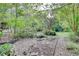 Landscaping area featuring a stone-lined path, water feature, and mature shrubs at 1660 Weems Rd, Locust Grove, GA 30248