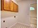 Cozy laundry room features upper cabinets, access for washer/dryer hookups, and classic tile floor at 1660 Weems Rd, Locust Grove, GA 30248