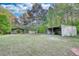 Exterior of outbuildings and vehicle storage spaces surrounded by a lush green lawn and trees at 1660 Weems Rd, Locust Grove, GA 30248