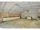 Large workshop interior featuring a metal roof, concrete floors, and built-in storage and workspace for various projects at 1660 Weems Rd, Locust Grove, GA 30248