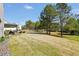 Spacious backyard showing a covered patio, fire pit, and lush green lawn, perfect for outdoor activities at 220 Alcovy Reserve Way, Covington, GA 30014