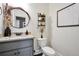 Stylish bathroom featuring a round mirror, granite countertop, and decorative wall shelves at 220 Alcovy Reserve Way, Covington, GA 30014