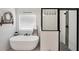 Modern bathroom featuring a soaking tub and a glass-enclosed shower with black hardware and fixtures at 220 Alcovy Reserve Way, Covington, GA 30014