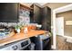 Functional laundry room with black cabinets, stylish backsplash, and a convenient folding table at 220 Alcovy Reserve Way, Covington, GA 30014