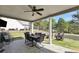 Inviting covered patio area with a ceiling fan, dining table, and outdoor seating for relaxing and entertaining at 220 Alcovy Reserve Way, Covington, GA 30014